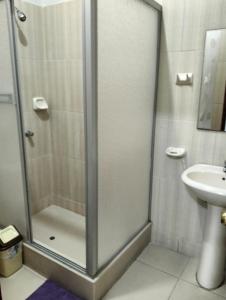 a shower with a glass door next to a sink at 203 RV Apartments Iquitos-Apartamento con dos habitaciones in Iquitos
