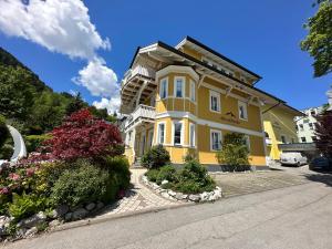 a yellow building with flowers in front of it at das zellersee in Zell am See