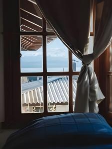 ventana del dormitorio con vistas a un edificio en Acogedora casa con vista al lago complejo turístico en San Carlos de Bariloche