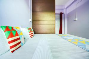 Un dormitorio con una cama con almohadas de colores. en Flagship The Alpine Homes en Solan