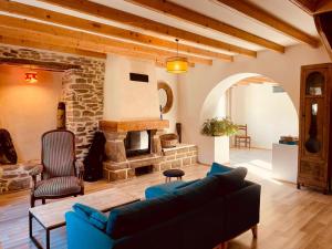 a living room with a couch and a stone fireplace at Le Bercail in Plouézec