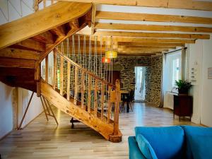 - un escalier en bois dans le salon doté d'un canapé bleu dans l'établissement Le Bercail, à Plouézec