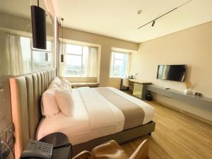 um quarto com uma cama grande e uma televisão em Vertigo Hotel em Lagos