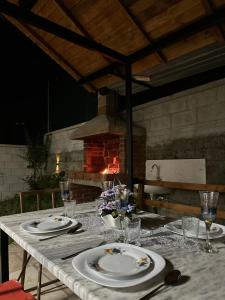 a table with plates and wine glasses and a fireplace at Villa For Rent in Durrës