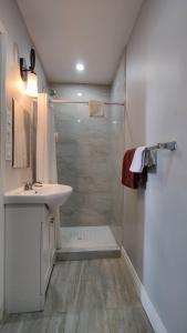 a white bathroom with a shower and a sink at Tulip Motel in Woodstock