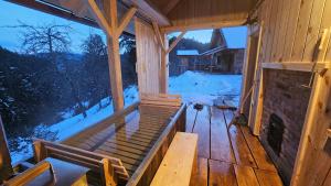 Cottage Golenovo في Podvelka: شرفة كابينة خشبية مع موقد