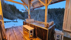 una veranda di una cabina con panchina e tavolo di Cottage Golenovo a Podvelka