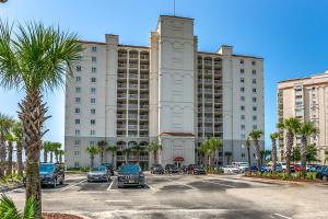 Un gran edificio con coches aparcados en un estacionamiento. en Lovely Studio - Yacht Club, en Myrtle Beach