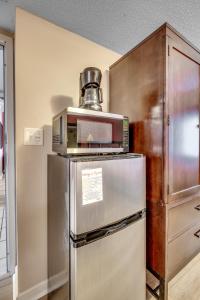 Un microondas encima de un refrigerador en una cocina. en Lovely Studio - Yacht Club, en Myrtle Beach
