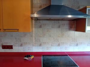 eine Küche mit einer Haube über einer roten Theke in der Unterkunft Rocio del Mar in Pontevedra
