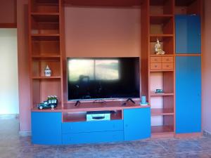 ein Wohnzimmer mit einem TV und einem blauen Entertainment-Center in der Unterkunft Rocio del Mar in Pontevedra
