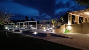 une terrasse avec des lumières devant un bâtiment la nuit dans l'établissement Tenuta I Quattro Venti, à Otrante