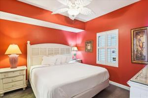 een slaapkamer met een wit bed en rode muren bij 1408 Seychelles in Panama City Beach +32 foto's