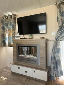 ディナールにあるMobil-home tout confortのリビングルーム(薄型テレビ、暖炉付)