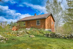 una casa de madera en una colina con una pared de piedra en Charming Lovell Cabin - 7 Mi to Kezar Lake!, en Lovell