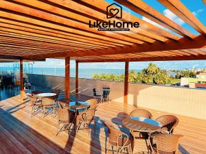 a patio with tables and chairs and the ocean at Paradise Pé na Areia -Bessa, LikeHome in João Pessoa