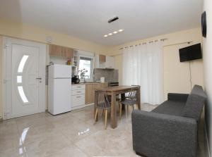 a kitchen and dining room with a table and a refrigerator at Haris Studio 1 in Keramoti