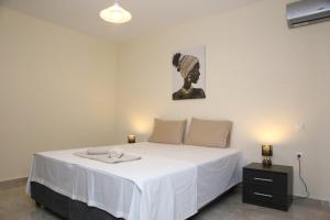 a bedroom with a large white bed with a table at Haris Studio 1 in Keramoti