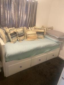 a bed with pillows on it with a window at Beautiful Chalet close to the beach in Eastchurch