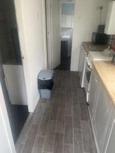 a small kitchen with a trash can in the floor at Beautiful Chalet close to the beach in Eastchurch