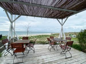 a wooden deck with tables and chairs and the ocean at Complex Turistic Răsărit Corbu in Corbu +51 photos