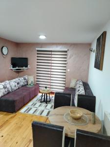 ein Wohnzimmer mit einem Sofa und einem Tisch in der Unterkunft Simic Apartmani Tara in Kaludjerske Bare