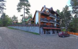 a house with a car parked in front of it at Simic Apartmani Tara in Kaludjerske Bare