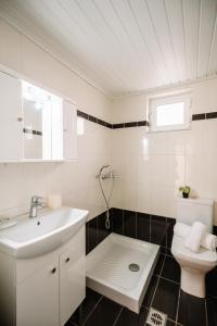 uma casa de banho branca com um lavatório e um WC em Country House in Agios Leon em Agios Leon