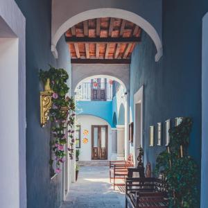 an archway in a building with blue walls and benches at Hotel Boutique Casa Altamira in Querétaro