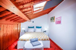 una camera da letto con un letto in una stanza con soffitti in legno di Casa Vereda, Ponta Delgada, S. Miguel a Ponta Delgada Altre 41 foto