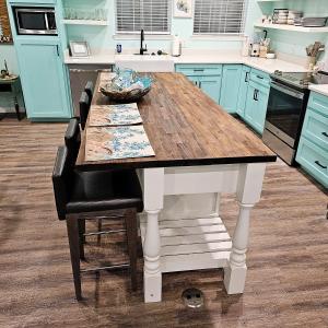 a kitchen with a wooden table and blue cabinets at Pat's Perch in Rockport