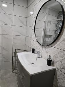 een witte badkamer met een wastafel en een spiegel bij LC's Guesthouse in Lagos