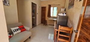 a small living room with a couch and a kitchen at Departamentos MG in Valladolid