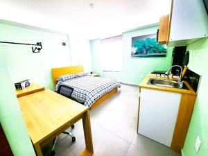 una cocina con fregadero y una cama en una habitación en A05 Full Suite ‖ Mini Dept at Plaza Acequia, en Cuautitlán Izcalli