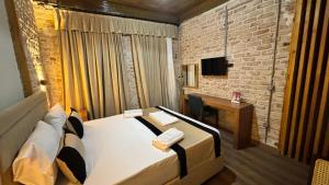 Habitación con cama, escritorio y TV. en Guest Hotel en Estambul