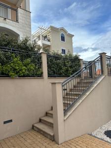 a building with stairs in front of a house at LUSTICA BAY GARDEN APARTMENT, Centrale in Tivat
