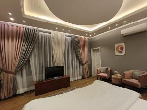 a bedroom with a bed and a flat screen tv at Royal Lodge By Hotel Demanchi in Murree