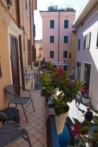 a balcony with tables and chairs and plants and buildings at Le Finestre sul Borgo Rooms in Peschiera del Garda