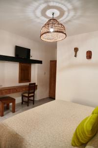 1 dormitorio con cama, escritorio y lámpara de araña en Hotel Mansión Chiapa, en Chiapa de Corzo