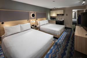 una camera d'albergo con due letti e una cucina di Accent Inns Vancouver Airport a Richmond
