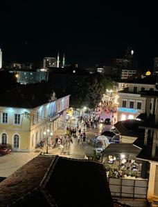 un grupo de personas caminando por una calle por la noche en Pedestrian Street Center Apartment, en Shkodër