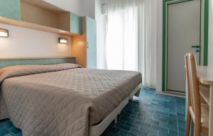a bedroom with a bed and a table and a window at Hotel Corallo in Gatteo a Mare +47 photos