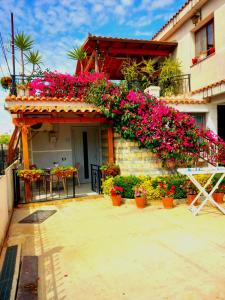 un edificio con flores a un lado. en villa Heljos apartaments, en Vlorë