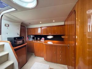 uma pequena cozinha com armários de madeira e uma janela em Motor Boat Accommodation em Torquay