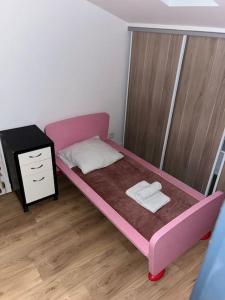 a small bedroom with a pink bed and a night stand at Villa Johana in Aucamville