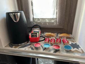 una mensola con cupcake e una macchinetta del caffè in un frigorifero di Nizza 90 a Torino