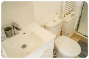 a white bathroom with a toilet and a sink at Qhome 4 - F2 entre Paris et Disney - Parking privé in Villiers-sur-Marne +14 photos