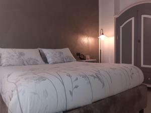 1 dormitorio con 1 cama grande y edredón blanco en L'Archetto Apartment, en Civitavecchia