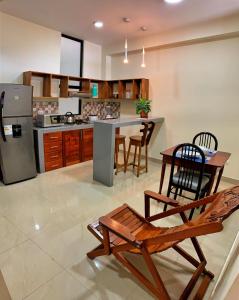 Studio 69 Aparthotel في إكيتوس: مطبخ مع طاولة وكراسي وكاونتر