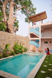 a woman sitting in front of a house with a swimming pool at Hotel Mansión Chiapa in Chiapa de Corzo